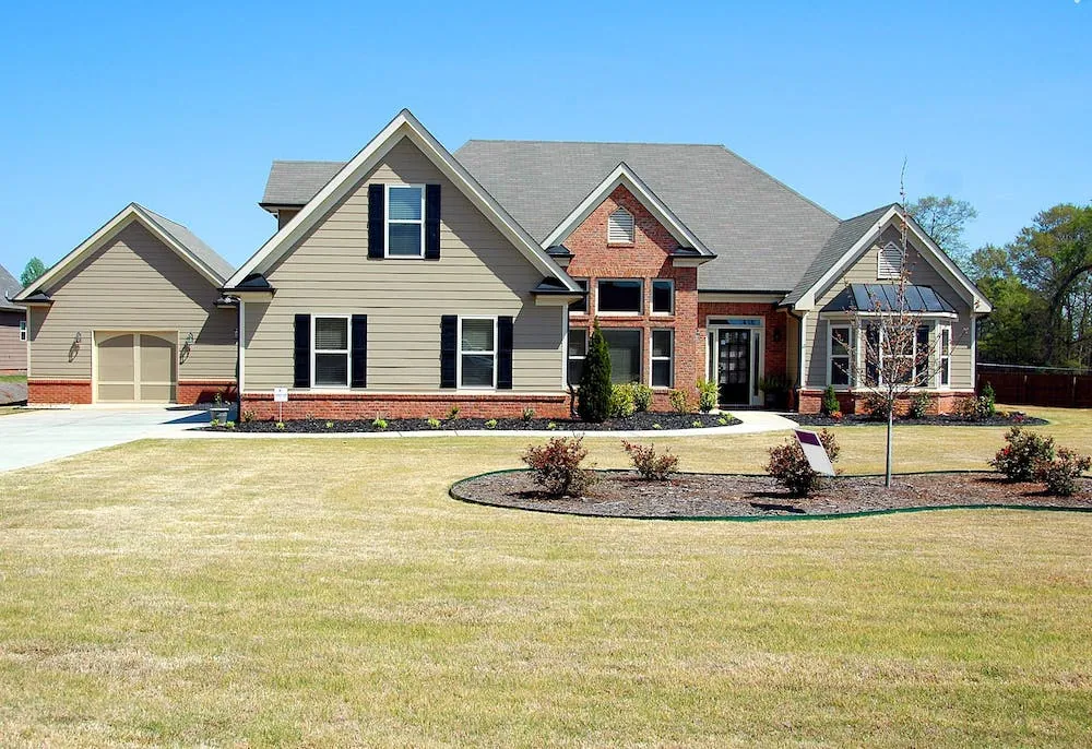 two story house with brick grass is yellowish